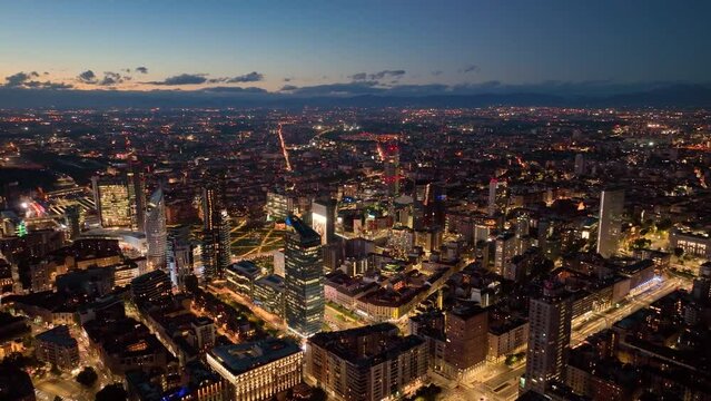 aerial view drone of milan financial district porta nuova skyscrapers at night, flying over city
