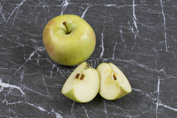 Whole and sliced apples on marble background
