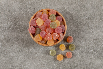 Top view of sweet colorful marmalade in wooden bowl