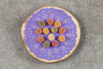 Top view of colorful sweet marmalade on wooden board