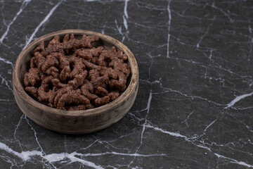 Chocolate cereal flakes in wooden bowl
