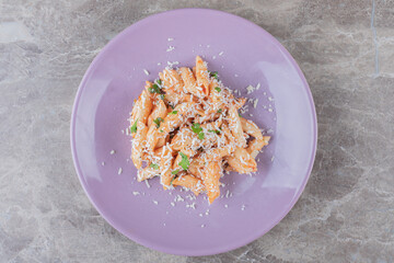 A small portion penne pasta , on the marble background