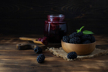 Large blackberries in a wooden bowl on a canvas napkin