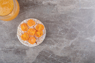 Porridge with tomatoes slices in a glass on a next to orange juice, on the marble background