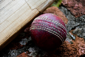 Old and unused cricket sport equipments on brick, bat, wicket, old leather ball, soft and selective...