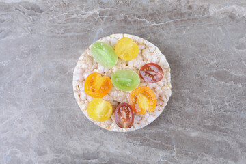 Different kinds of fruits on the puffed rice cakes, on the marble background
