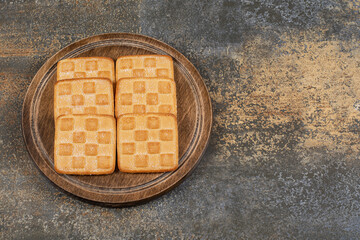 Square sweet crackers on wooden board