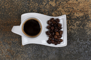 Espresso with coffee beans on white saucer