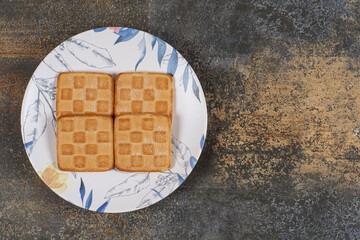 Delicious sweet crackers on colorful plate