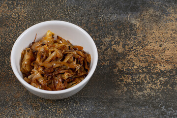 Caramelized onion pieces in white bowl