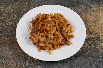 Caramelized onion pieces on white plate