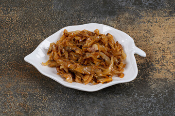 Fried caramelized onion pieces on leaf shaped plate
