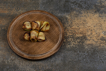 Obraz na płótnie Canvas Fried eggplant rolls on wooden board