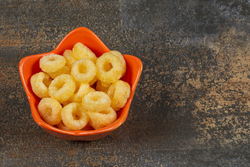 Tasty cereal rings in orange bowl