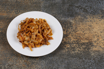 Caramelized onion pieces on white plate
