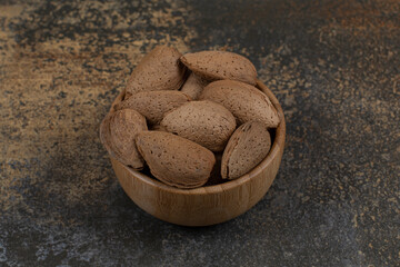 Raw shelled almonds in wooden bowl