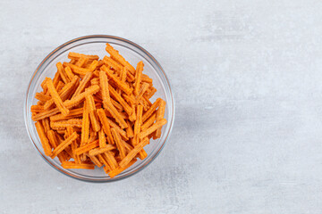 Close up photo of fresh fries in glasses bowl over white background