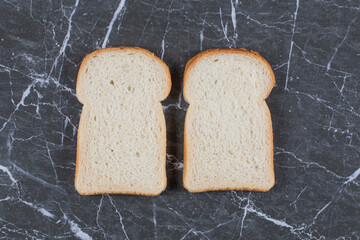 Two fresh bread slices on grey background