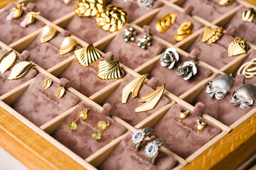 Vintage old-fashioned earrings at flea market stall or car boot sale. Retro style jewelry. Vintage goods for sale. Garage sale concept. Selective focus