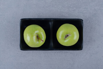 Top up view of fresh green apple on grey background