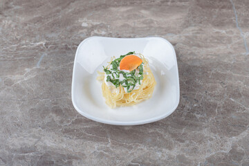 Tasty spaghetti with carrot on the plate , on the marble background