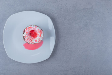 Top view of fresh creamy muffin on white plate