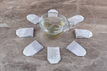 Cup of tea with tea bags, on the marble background