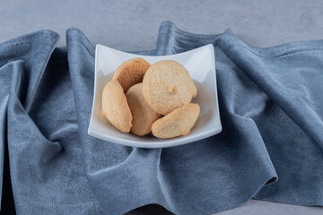 Fresh homemade cookies on white bowl over grey background