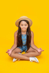Fototapeta na wymiar teen girl in straw hat meditating on yellow background