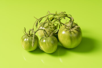 Fresh green tomatoes on a solid background