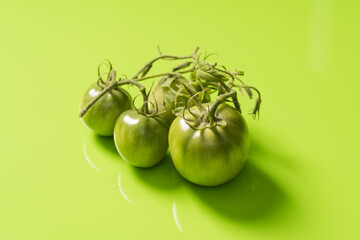 Fresh green tomatoes on a solid background