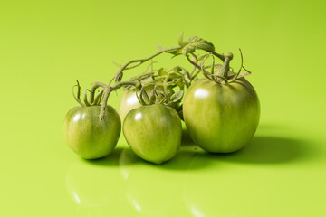 Fresh green tomatoes on a solid background