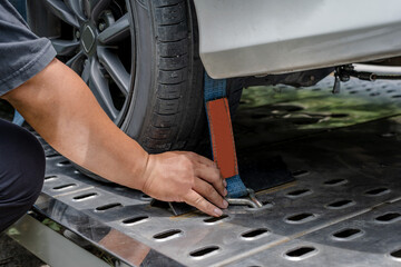 Close up towing man hand locking broken car with belt for security on towing truck,
Car Insurance...