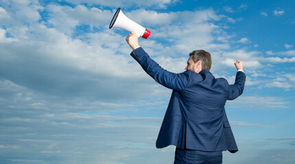 back view of businessman hold loudspeaker on sky background. copy space