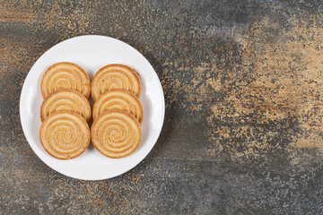Pile of tasty round biscuits on white plate