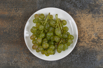 Cluster of green grapes on white plate