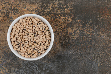 Pile of raw white beans in white bowl