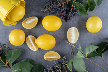 Top view of fresh lemons and lemon slices with leaves