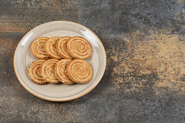 Tasty biscuits with sesame seeds on ceramic plate