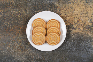 Pile of tasty round biscuits on white plate