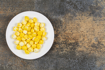 Yellow hard candies on white plate