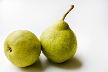 Two green ripe pears on a white background in autumn. Two fruits of a green pear in close-up.