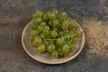 Fresh green grapes on ceramic plate