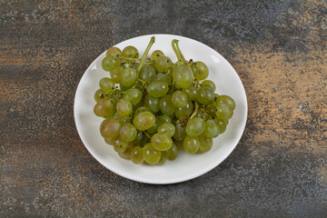 Cluster of green grapes on white plate