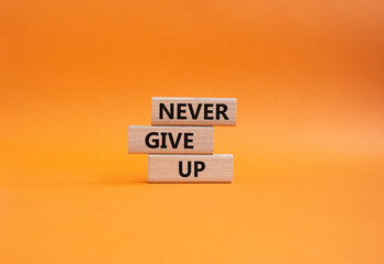 Never give up symbol. Concept words Never give up on wooden blocks. Beautiful orange background. Business and Never give up concept. Copy space.