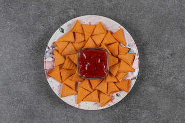 Triangle shaped crackers on plate with ketchup