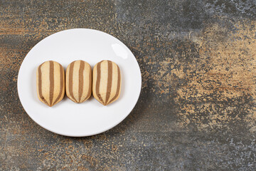 Delicious chocolate striped biscuits on white plate
