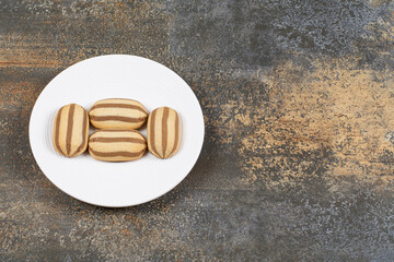 Delicious chocolate striped biscuits on white plate