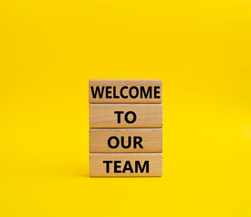 Welcome to our team symbol. Concept words Welcome to our team on wooden blocks. Beautiful yellow background. Business and Welcome to our team concept. Copy space.