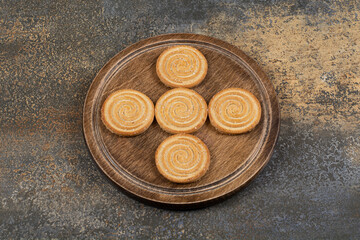 Pile of tasty biscuits on wooden plate